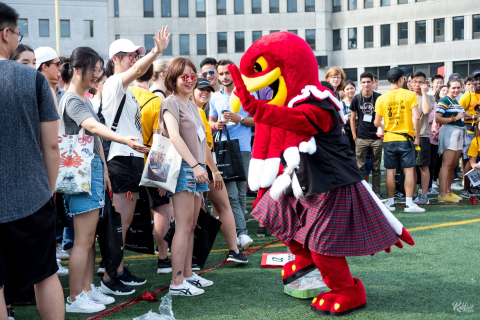 a group of students dancing with Marty, the McGill mascot